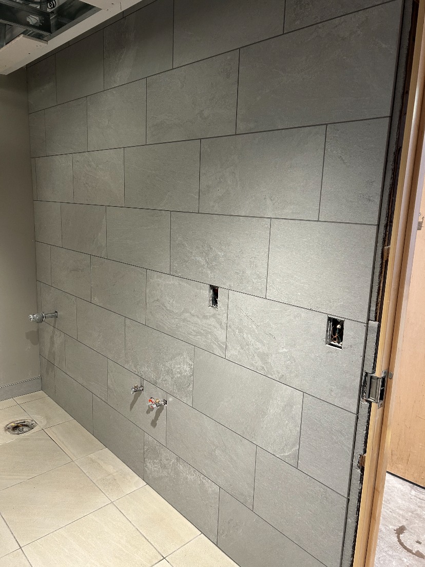 Large-format tile wall installation in Commercial restroom